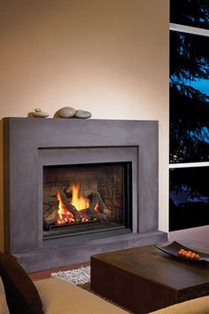 a living room filled with furniture and a fire place in front of a large window