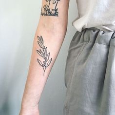 a woman with a tattoo on her arm holding onto the arm of another person's arm