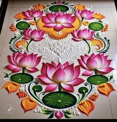 an intricately designed painting on the floor with flowers and leaves in pink, yellow and green