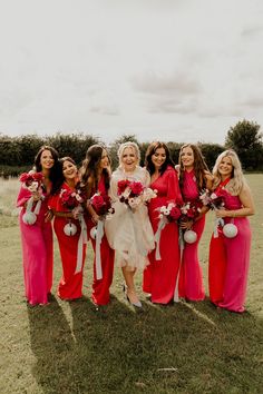 a group of women standing next to each other on top of a lush green field