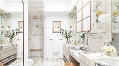 a bathroom with marble counter tops and gold accents on the walls, along with two sinks