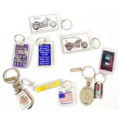 several different key chains and tags on a white surface