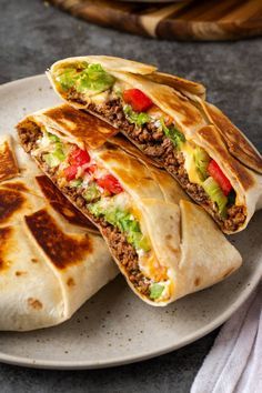 two burritos cut in half on a plate