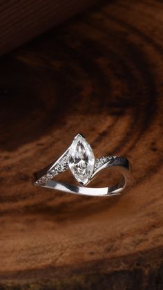 a diamond ring sitting on top of a wooden surface