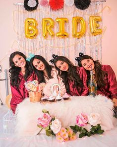 three women pose for a photo in front of a cake