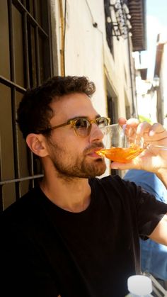 a man drinking from a wine glass in front of a window with the caption that reads,