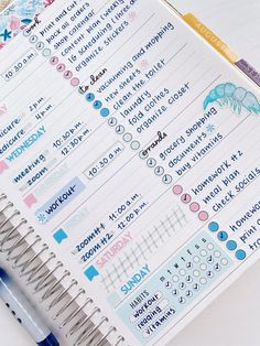 an open planner with stickers on it next to a pen and paper clipping