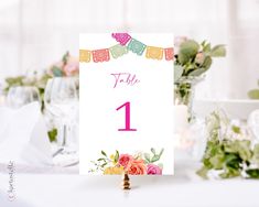 a table number with flowers and bunting on it