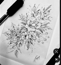 a drawing of flowers on paper next to a pen