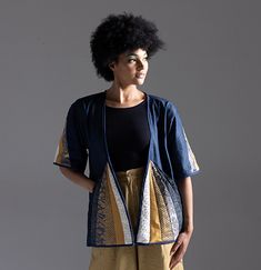 a woman with an afro standing in front of a gray background