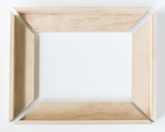 an empty wooden frame on a white wall