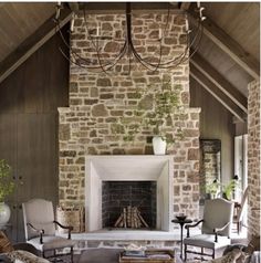 a living room with stone fireplace and vaulted ceiling