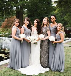 a group of women standing next to each other on top of a grass covered field