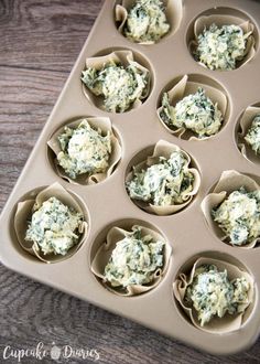 cupcakes filled with spinach and cheese in a muffin tin on a wooden table