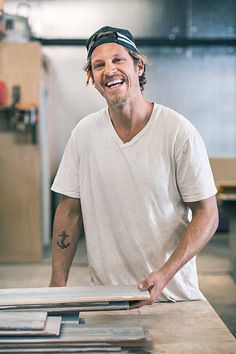 a man standing in front of a table with wooden boards on it