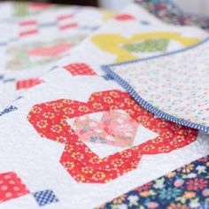 a close up of a quilt on top of a table cloth with an image of a heart in the center