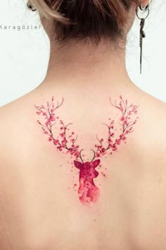 the back of a woman's neck with watercolor deer and flowers on it