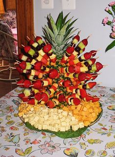 a fruit platter with pineapples, strawberries and apples arranged in the shape of a tree