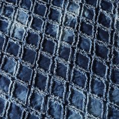 an up close shot of the texture of a blue velvet fabric with small squares on it