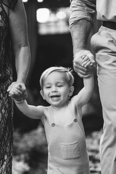 a small child holding the hand of an adult