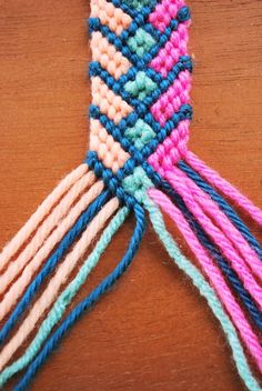 a close up of a piece of yarn on a wooden surface with two strings attached to it