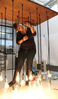 a woman standing in front of a bunch of light bulbs