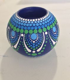 a blue and green vase sitting on top of a table