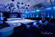 an empty dance floor is lit up with blue and white lights for a corporate event