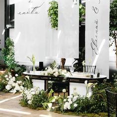 a table with white flowers and greenery on it