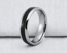 a black and white wedding ring on top of a plain cloth background, with the center in