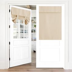 an open white door with beige curtains on it