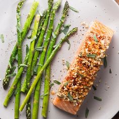 a white plate topped with asparagus and salmon