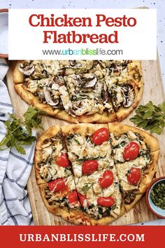 two chicken flatbread pizzas with tomatoes, mushrooms and spinach on a cutting board