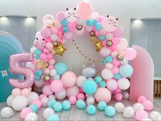 the balloon arch is decorated with pink, blue and white balloons that spell out 5