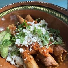 a bowl filled with meat and rice on top of a table