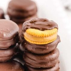 chocolate covered cookies are stacked on top of each other with a yellow cookie in the middle