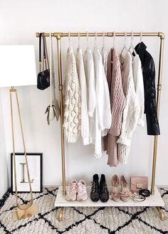 a rack with shoes and sweaters hanging on it