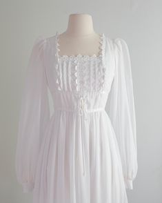 a white dress on a mannequin dummy with long sleeves and ruffles