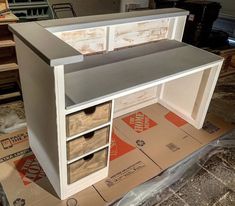 an unfinished desk with drawers on top of it