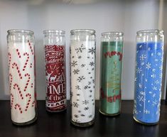 six different colored candles are lined up on a table with snowflakes and stars