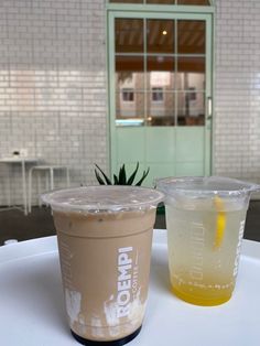 two drinks sitting on top of a table next to each other