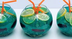 two glasses filled with green liquid and orange straws