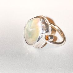 "Handmade with love at Kacha Stones UK: O 1/2 USA 7 1/2 EU: 55 This unique Sterling silver design is set with a beautiful cream Keshi Pearl and golden Tourmaline.  Keshi pearls come in a variety of colours, often reflecting the natural colours of the host oyster's species. Keshi pearls exhibit a beautiful lustre, often with a high sheen and metallic iridescence. They possess a remarkable glow and surface brilliance and are relatively rare because they are a natural byproduct of the culturing pro White High Luster Pearl Ring For Wedding, Unique High Luster Wedding Jewelry, Unique High Luster Jewelry For Wedding, Unique Oval Pearl Gemstone Ring, High Luster White Pearl Ring For Anniversary, Heirloom White Pearl Ring With Gemstone, Unique Faceted Wedding Rings, Anniversary Pearl Rings With Gemstones, White Fusion Style Gemstone Ring