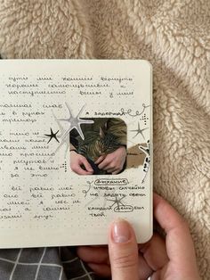 a person holding a cat in front of a notepad with writing and pictures on it