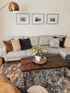 a living room with a couch, coffee table and pictures on the wall above it