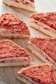 several pieces of cake that are sitting on a piece of parchment paper with red sprinkles