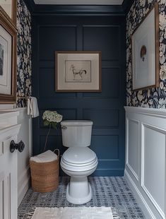 a white toilet sitting in a bathroom next to a wall with pictures on the walls