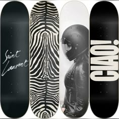 four skateboards with different designs on them, one has a helmet and the other has a zebra print