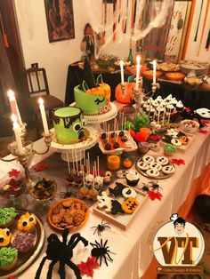 a table topped with lots of halloween desserts