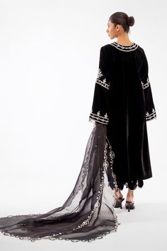 This classic silhouette is cut from lustrous black velvet and features detailed zardoze work. Gota tassels and scalloped hems on the trousers give this coord set a finished look. This outfit is paired with an eyelet embroidered organza dupatta. Evening Palazzo Set With Sheer Dupatta For Eid, Palazzo Set With Dupatta For Evening Eid, Evening Palazzo Set With Dupatta For Eid, Eid Evening Palazzo Set With Dupatta, Elegant Embroidered Evening Palazzo Set, Elegant Embroidered Palazzo Set For Evening, Party Velvet Sets With Sheer Dupatta, Velvet Party Sets With Traditional Drape, Anarkali Style Evening Sets With Dabka Work